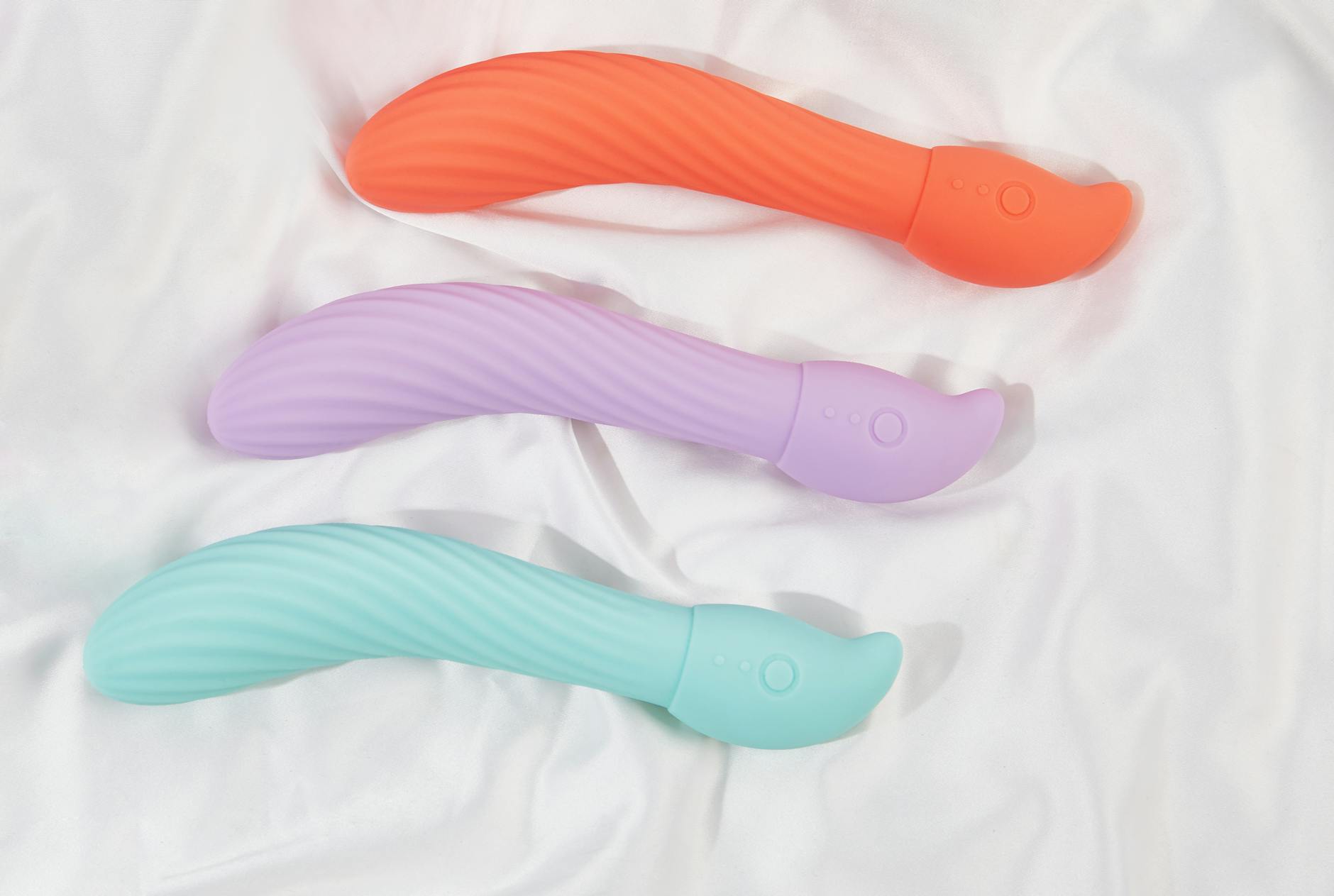 Woman holding blue and pink silicone vibrators, considering options for pleasure recovery