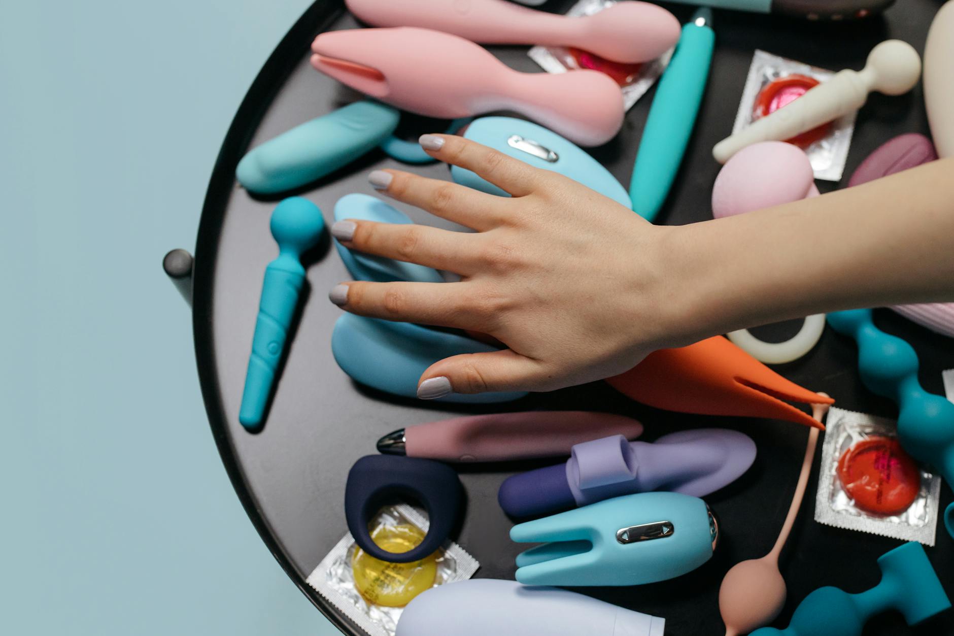 Woman holding colorful vibrators, representing reconnection with pleasure